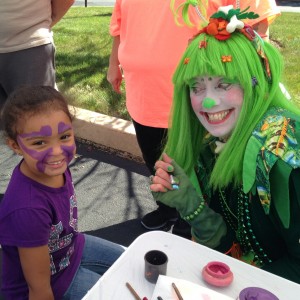 Wink, the clown, paints a happy girl's face at Asher's Annual Fall Fest