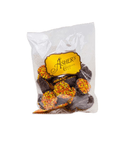 A 4 oz. bag of Ashers Chocolate Co. Dark Chocolate Fall Nonpareils features delicious chocolate candies topped with orange, yellow, and red sprinkles.