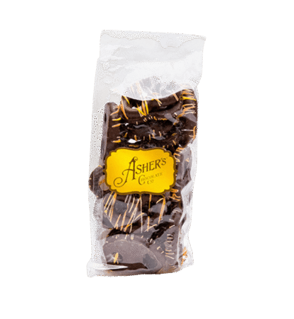 A 4 oz. bag of Dark Chocolate Fall Mini Pretzels, each crisp treat coated in rich dark chocolate and adorned with a festive orange drizzle, sits against a plain white background. The clear plastic bag is sealed at the top and features an Ashers Chocolate Co. yellow sticker on the front.