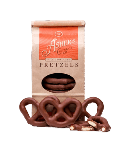 A bag of Milk Chocolate Covered Pretzel Coffee Bag with several whole and broken pretzels displayed in front.