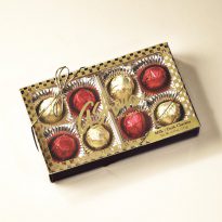 Assorted Cherry Cordials Gift Box displays milk and dark cherry cordials wrapped in gold and red foil. Eight (8) candies are packed in a brown gift box with clear lid and golden ribbon.