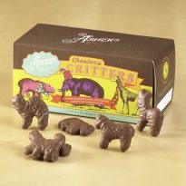Chester's Critters Milk Chocolate are scattered in front of Snack Box to reveal size, shape, color, and texture of cookies. Snack Box has colorful, animated artwork of a pink hippo, purple elephant, and yellow giraffe.