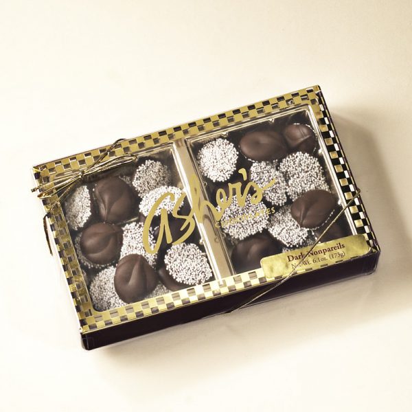 Dark Chocolate Nonpareils Gift Box with gold ribbon and clear lid to show dark chocolate nonpareils with white seeds inside
