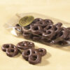 Mini Milk Chocolate three (3) ring Pretzels in clear Cello Bag with four (4) mini pretzels outside of bag to reveal color, size, shape, and texture.