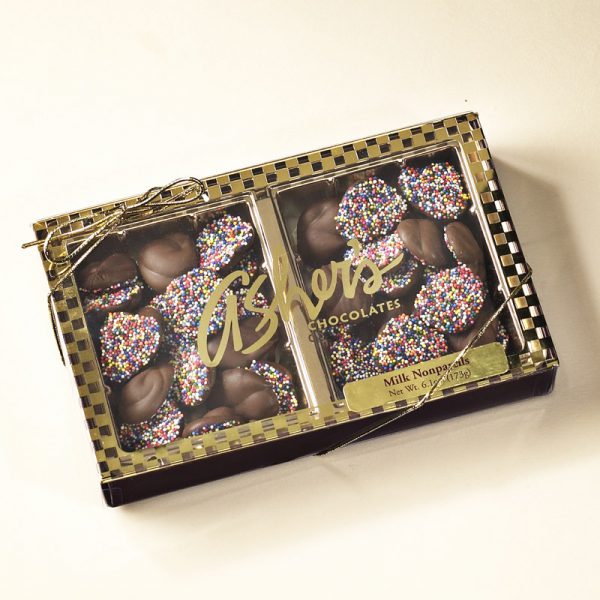 Milk Chocolate Nonpareils Gift Box with gold ribbon and clear lid to show milk chocolate nonpareils with rainbow seeds inside.