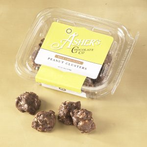 Milk Chocolate Peanut Clusters Fresh Pack with yellow and white Asher's label. Four (4) Milk Chocolate Peanut Clusters are outside of the Fresh pack to reveal size, color, filling, and texture of candies.