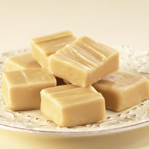 Vanilla Fudge squares piled on a white plate.