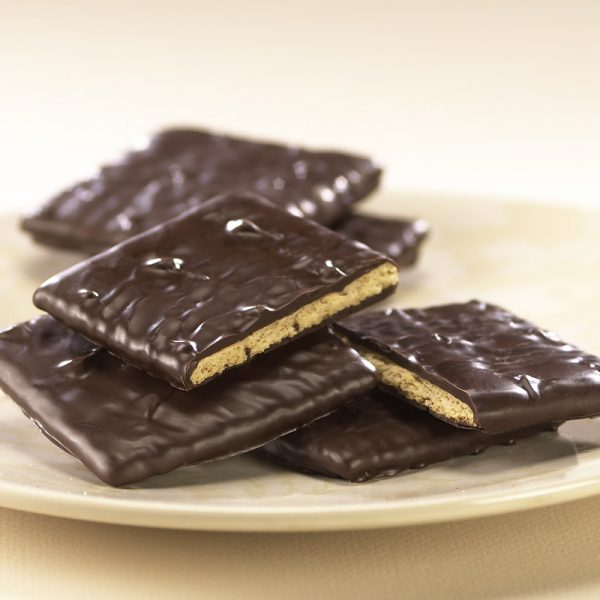 Dark Chocolate Graham Crackers lie on a pile of Grahams. The two (2) focal grahams are broken open to reveal the golden graham inside