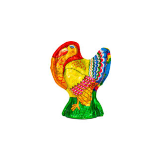 A solid milk chocolate turkey, weighing 6 ounces, wrapped in colorful foil featuring vibrant red, yellow, blue, and green patterns. Reminiscent of a festive holiday centerpiece, the turkey stands upright on a green base against a plain white background.