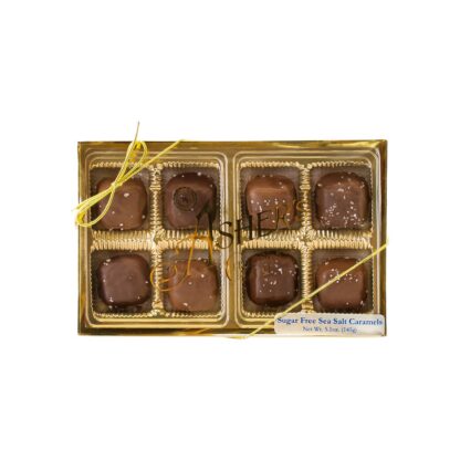 A gold box labeled “Sugar Free Sea Salt Caramels Grab-A-Gift” holds eight delectable sugar free caramels, each chocolate-coated and topped with sea salt. The candies are separated by gold dividers and finished with a gold ribbon.