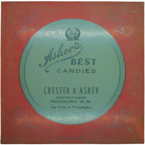 Square candy box lid with ornate text: Ashers Best Candies. Chester A. Asher, Confectioner, Philadelphia 44, PA. The Pride of Philadelphia. Decorative border and floral elements in corners, celebrating asher’s chocolate history as a cherished part of the city’s sweet traditions.