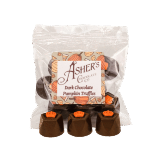 A clear bag labeled Ashers Dark Chocolate Pumpkin Truffles contains round chocolates with orange pumpkin decorations. Four truffles are displayed in front of the bag.
